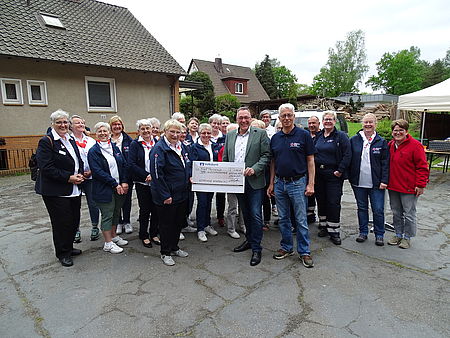 im Beisein des Vorstandes und der Aktiven des DRK-Ortsvereins überreicht Bürgermeister Oelmann den Scheck der Gemeinde Winsen (Aller) an Teamleiterin Kleiderkammer Frau de Schipper und Frau Meyer
